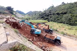 Máy xúc, ôtô được huy động để xúc, ủi, san gạt, đảm bảo thông tuyến nhanh nhất. (Ảnh: Quang Quyết/TTXVN)