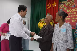 Phó Chủ tịch Thường trực Quốc hội Trần Thanh Mẫn tặng quà gia đình chính sách xã Thạnh Xuân. (Ảnh: Hồng Thái/TTXVN)