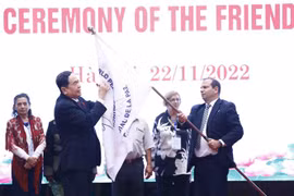 Phó Chủ tịch thường trực Quốc hội Trần Thanh Mẫn ký lên lá cờ của Hội đồng Hòa bình thế giới. (Ảnh: Minh Đức/TTXVN)