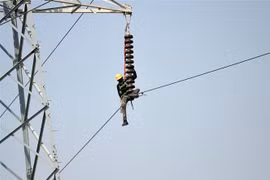 Kỹ thuật viên sửa chữa đường dây điện cao thế tại Karachi, Pakistan. (Ảnh: AFP/ TTXVN)
