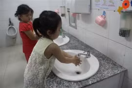 Hướng dẫn trẻ rửa sạch tay trước khi ăn và sau khi vệ sinh tại Trường mầm non phường 1, quận 10. (Ảnh: Đinh Hằng/TTXVN)