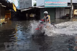 Nước ngập sâu trên đường phường Thạnh Lộc. (Ảnh: Mạnh Linh/TTXVN)