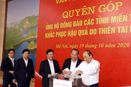 Thủ tướng Nguyễn Xuân Phúc và các Phó Thủ tướng ủng hộ đồng bào niền Trung khắc phục hậu quả do do thiên tai lũ lụt. (Ảnh: Thống Nhất/TTXVN)