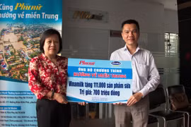 Ông Nguyễn Trung, Chủ tịch Công đoàn Công ty Vinamilk đại diện tập thể người lao động của công ty trao bảng tượng trưng 111.000 sản phẩm dinh dưỡng ủng hộ đồng bào miền Trung. (Nguồn: Vietnam+)