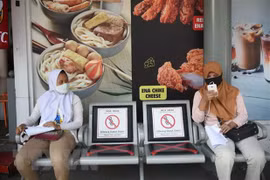 Người dân đeo khẩu trang và thực hiện giãn cách xã hội phòng lây nhiễm COVID-19 tại Jakarta, Indonesia. (Ảnh: THX/TTXVN)