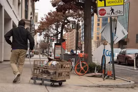 Một nhân viên phân phát thực phẩm trên một đường phố ở Washington, DC, Mỹ. (Ảnh: AFP/TTXVN)