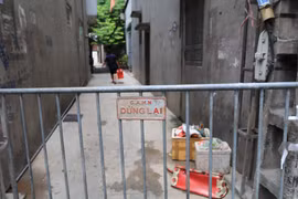 Lực lượng chức năng phong tỏa khu vực ngõ 230/26 Mễ Trì Thượng, nơi có trường hợp nghi nhiễm COVID-19 đang sinh sống để phun thuốc khử khuẩn. (Ảnh: Lê Phú/TTXVN)