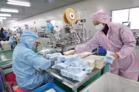 Công nhân may khẩu trang y tế tại một nhà máy ở Vũ Hán, Trung Quốc. (Nguồn: THX/TTXVN)