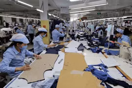 May hàng xuất khẩu tại Công ty trách nhiệm hữu hạn may Đức Giang, Long Biên, Hà Nội. (Ảnh: Trần Việt/TTXVN)