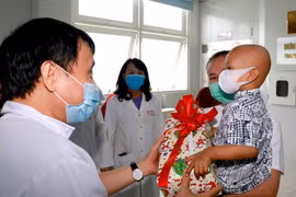 Lãnh đạo bệnh viện tặng quà cho bệnh nhi ngày ra viện. (Ảnh: TTXVN phát)
