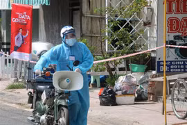 Lực lượng chức năng thị trấn Phú Mỹ, huyện Phú Tân tăng cường công tác tuyên truyền lưu động đến tận sâu trong các khu phong tỏa nhằm nhắc nhỏ, nâng cao ý thức phòng, chống dịch của người. (Ảnh: Công Mạo/TTXVN)