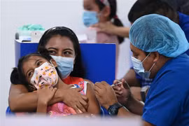  Nhân viên y tế tiêm vaccine ngừa COVID-19 cho trẻ em trong độ tuổi từ 6-11 tại San Salvador, El Salvador ngày 22/9/2021. (Ảnh: AFP/TTXVN)