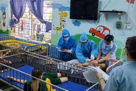 Các y bác sỹ lực lượng tăng cường của Bộ Lao động, Thương binh và Xã hội tiêm vaccine phòng COVID-19 cho người khuyết tật tại Trung tâm Bảo trợ trẻ tàn tật mồ côi Thị Nghè. (Ảnh: Thanh Vũ/TTXVN)