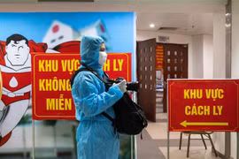 Phóng viên Minh Quyết, Ban Biên tập Ảnh TTXVN tác nghiệp trong khu cách ly phòng COVID-19 của Viện Huyết học Truyền máu Trung ương. (Ảnh: TTXVN)