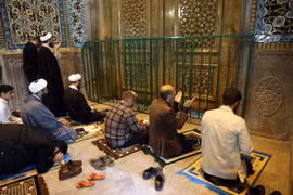 Các tín đồ Hồi giáo cầu nguyện bên ngoài đền thờ Fatima Masumeh ở thành phố Qom (Iran) sau khi đền thờ này đóng cửa do dịch COVID-19 ngày 16/3/2020. (Ảnh: AFP/TTXVN)