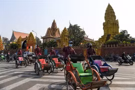 Người dân đeo khẩu trang phòng chống COVID-19 trên một đường phố ở Phnom Penh, Campuchia. (Ảnh: AFP/TTXVN)