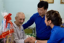 Anh Lê Quốc Phong, Ủy viên dự khuyết Trung ương Đảng, Bí thư thứ nhất Trung ương Đoàn tặng quà cho cựu chiến binh Đoàn Hà. (Ảnh: Hồng Giang/TTXVN)