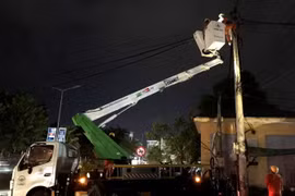 Công nhân ngành điện làm việc xuyên đêm để khôi phục điện lưới. (Ảnh: Tường Vi/TTXVN)
