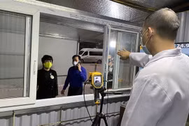 Mọi người dân và du khách được đo thân nhiệt trước khi vào hoặc ra khỏi vùng biên giới Móng Cái. (Ảnh: Văn Đức/TTXVN)