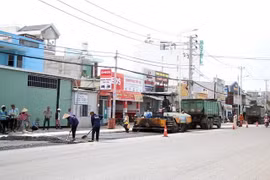 Các đơn vị thi công thảm nhựa tại dự án nâng cấp, mở rộng đường Tô Ký, Hóc Môn, TP.HCM. (Ảnh: Tiến Lực/TTXVN)