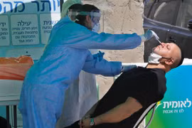 Nhân viên y tế lấy mẫu dịch xét nghiệm COVID-19 cho người dân tại thành phố Lod, Israel ngày 2/7/2020. (Ảnh: THX/TTXVN)