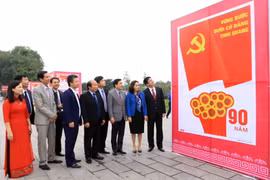 Các đại biểu tham quan khu vực trưng bày tranh cổ động chào mừng 90 năm thành lập Đảng và 70 năm thành lập tỉnh Vĩnh Phúc. (Ảnh: Hoàng Hùng/TTXVN)