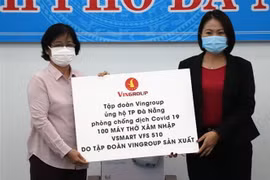 Chủ tịch Ủy ban Mặt trận Tổ quốc Việt Nam thành phố Đà Nẵng Đặng Thị Kim Liên (bên trái) nhận ủng hộ của đại diện Tập đoàn Vingroup. (Ảnh: Quốc Dũng/TTXVN)