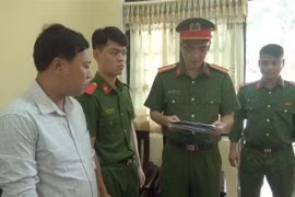 Công an đọc lệnh bắt tạm giam Lê Mai Sáng. (Ảnh: TTXVN)