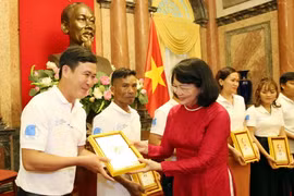 Phó Chủ tịch nước Đặng Thị Ngọc Thịnh tặng ảnh chân dung Chủ tịch Hồ Chí Minh cho các gia đình tiêu biểu năm 2020. (Ảnh: Dương Giang/TTXVN)
