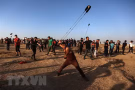 Người biểu tình Palestine ném đạn hơi cay trong cuộc đụng độ với binh sỹ Israel tại khu vực biên giới Dải Gaza-Israel ở phía đông thành phố Gaza ngày 27/9/2019. (Ảnh: THX/TTXVN)