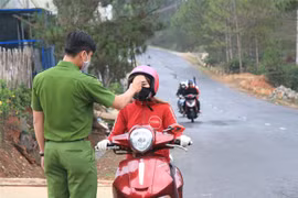 Đo thân nhiệt người điều khiển phương tiện giao thông tại chốt kiểm dịch. (Ảnh: Đặng Tuấn/TTXVN)