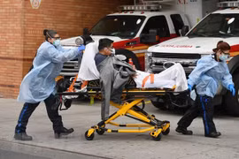 Nhân viên y tế chuyển bệnh nhân mắc COVID-19 vào một bệnh viện ở New York, Mỹ. (Ảnh: AFP/TTXVN)