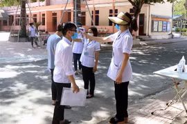 Kiểm tra thân nhiệt cho thí sinh. (Nguồn: TTXVN)