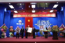 Phó Thủ tướng Chính phủ Trịnh Đình Dũng trao Quyết định công nhận thành phố Pleiku đạt tiêu chí đô thị loại I trực thuộc tỉnh Gia Lai. (Ảnh: Hoài Nam/TTXVN)