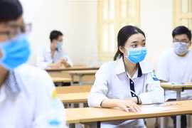 Các thí sinh đeo khẩu trang khi làm bài thi tại điểm trường THCS Đống Đa (Hà Nội). (Ảnh: Thành Đạt/TTXVN)