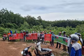 Người dân căng băngrôn, phát loa để đòi tiền đã mua đất trước đó tại dự án An Điền. (Ảnh: TTXVN)
