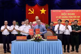 Thiếu tướng Bùi Quốc Oai, Bí thư Đảng ủy Bộ Tư lệnh Cảnh sát biển Việt Nam và ông Phạm Bạch Đằng, Phó Bí thư Thường trực Tỉnh ủy Cà Mau ký kết Chương trình phối hợp thực hiện công tác dân vận 'Cảnh sát biển đồng hành với ngư dân'' tại buỗi lễ. (Ảnh: Kim H