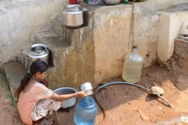 Các em nhỏ lấy nước vào can nhựa từ đường ống cấp nước của chính phủ ở ngoại ô Hyderabad, Ấn Độ. (Nguồn: AFP/TTXVN)