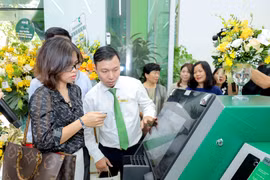 Khách hàng trải nghiệm các dịch vụ ngân hàng số mới nhất tại trụ sở mới Vietcombank Ba Đình. (Ảnh: Vietnam+)
