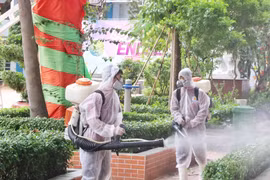 Nhân viên y tế phun thuốc khử khuẩn khu vực sân trường, cây cối, đảm bảo vệ sinh cho khuôn viên trường. (Ảnh: Thu Hương/TTXVN)