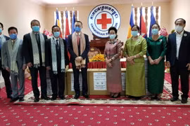 Đại diện Hội chữ thập đỏ Việt Nam Đại sứ Vũ Quang Minh ký bàn giao và trao quà tặng thiết bị y tế cho Hội chữ thập đỏ Campuchia. (Ảnh: PV/TTXVN)