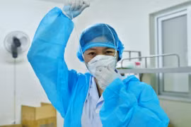 Bác sỹ chuẩn bị đồ bảo hộ vào phòng bệnh nhân COVID-19. (Ảnh: Minh Quyết/TTXVN)