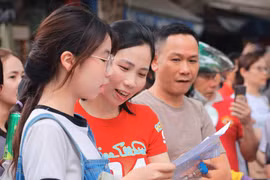 Phụ huynh, thí sinh xem lại bài sau khi rời phòng thi. (Ảnh: TTXVN) 