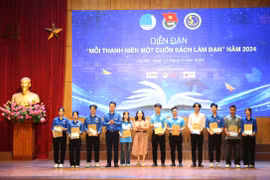 Ban tổ chức tặng sách cho các sinh viên tại diễn đàn. (Ảnh: PV/Vietnam+)