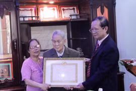 Ông Hà Anh Dân, (ngoài cùng bên phải) đang trao quyết định của Đảng Cộng sản Việt Nam tặng Huy hiệu 65 năm tuổi Đảng cho ông Trần Văn Mỹ. (Ảnh: Phạm Kiên/Vietnam+)
