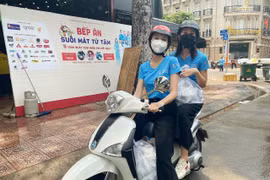 Hoa hậu Tiểu Vy và Á hậu Ngọc Thảo làm 'shipper' đi trao các suất ăn cho lực lượng đầu chống dịch. (Ảnh: CTV/Vietnam+)
