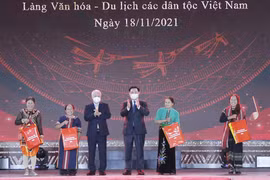 Chủ tịch Quốc hội Vương Đình Huệ và Chủ tịch Ủy ban Trung ương Mặt trận Tổ quốc Việt Nam Đỗ Văn Chiến trao quà cho các đại biểu dân tộc tại Làng Văn hóa. (Ảnh: Doãn Tấn/TTXVN)
