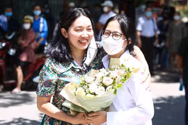 Một phụ huynh tặng hoa chúc mừng con gái hoàn thành tốt bài thi môn tổ hợp. (Ảnh: Phúc Tá/Vietnam+)