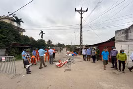 Lực lượng chức năng tháo dỡ lều bạt, băng rôn, khẩu hiệu dựng trái phép trên hành lang giao thông ở khu vực xã An Phượng. (Ảnh: Mạnh Tú/TTXVN)