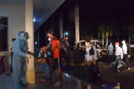 Các lực lượng chuyên môn tiến hành kiểm tra sức khỏe, khám sàng lọc ban đầu cho 116 công dân Việt Nam trở về từ Philippines. (Ảnh: Chương Đài/TTXVN)